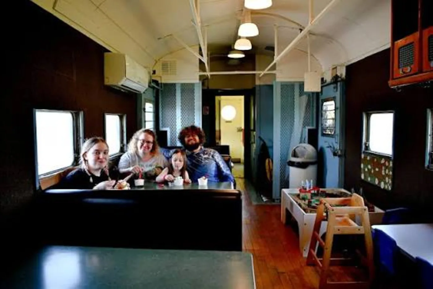 Family seated inside the restored train car